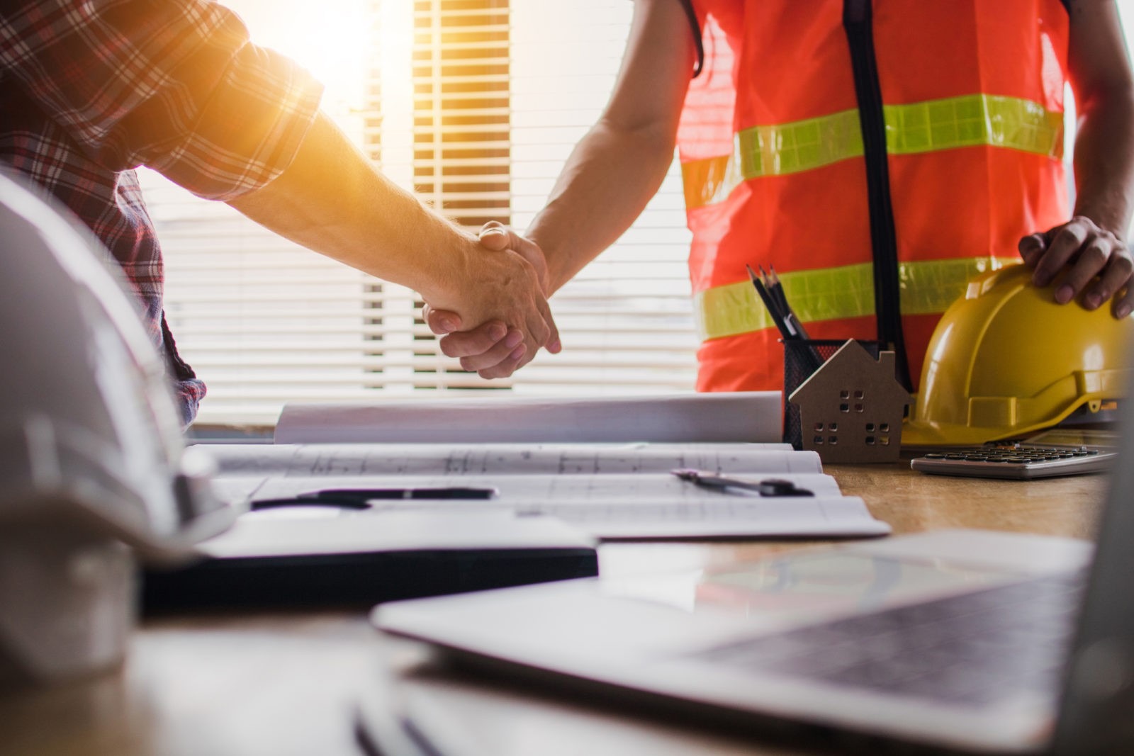 Handshake of two business man, after architect working and planning blueprint, Engineering objects on workplace